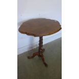 A Victorian walnut side table with a shaped top on a tripod base - Height 71cm x 59cm x 47cm