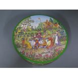 A circular Huntley and Palmer biscuit tin depicting a Tea Party, the table with a full spread,