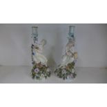 A pair of Continental porcelain figural candlesticks both with figures of ladies with birds