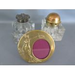 Two glass inkwells and a brass picture frame with oval shaped aperture,