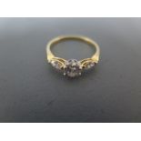 A three stone diamond ring set in yellow gold, the central diamond approx 1/2ct,