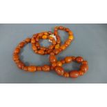An amber and Bakelite necklace approx 110cm in length, alternate large and small beads,