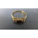 A 9ct yellow gold diamond and ruby ring - weight approx 2 grams - some usage wear