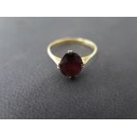 An 18ct yellow gold and oval cut garnet dress ring - approx weight 1.