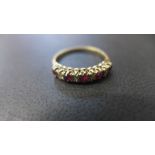A 9ct yellow gold dress ring with five rubies and eight small diamonds to shoulder - ring size O -