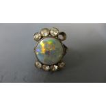 A yellow metal opal and diamond ring - the central circular opal flanked by seven diamonds each