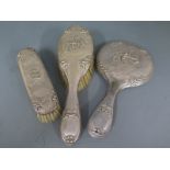 A silver hallmarked dressing set consisting of hairbrush, clothes brush and hand mirror,