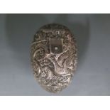 A hallmarked silver nutmeg holder with profusely embossed decoration, silver gilt interior,