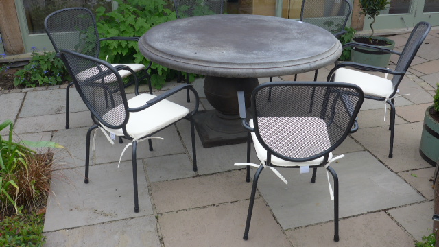 A Bramblecrest 140cm Venetian round concrete table with six mesh chairs and cushions