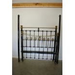 A brass and cast iron 4ft 6in double bed - finished in black with irons to sides - sprung base