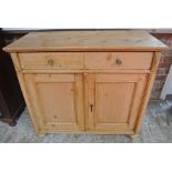 A 19th century stripped pine two drawer two door cupboard - Height 93cm x 103cm x 48cm