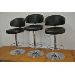 Three adjustable chrome and black leather bar stools