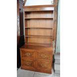 A walnut bookcase on base shelves over four deep filing drawers raised on plinth base - 103cm x 61.