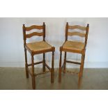 A pair of oak bar stools with rush seats - Height 105cm