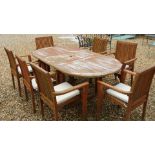 A wooden garden table with seven armchairs