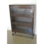 An oak glazed bookcase with three glazed lift up doors - Height 124cm x 86cm x 29cm