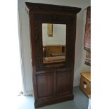 A carved oak hall cupboard with a mirrored front and paneled doors to each side - Height 211cm x