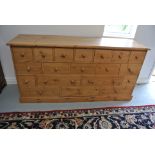 A modern pine merchants type chest with nineteen drawers - Height 90cm x 180cm x 50cm