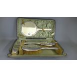 A four piece silver dressing table set - boxed - some denting and usage wear