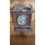An oak mantle clock with a silvered dial striking on a gong - Height 28cm
