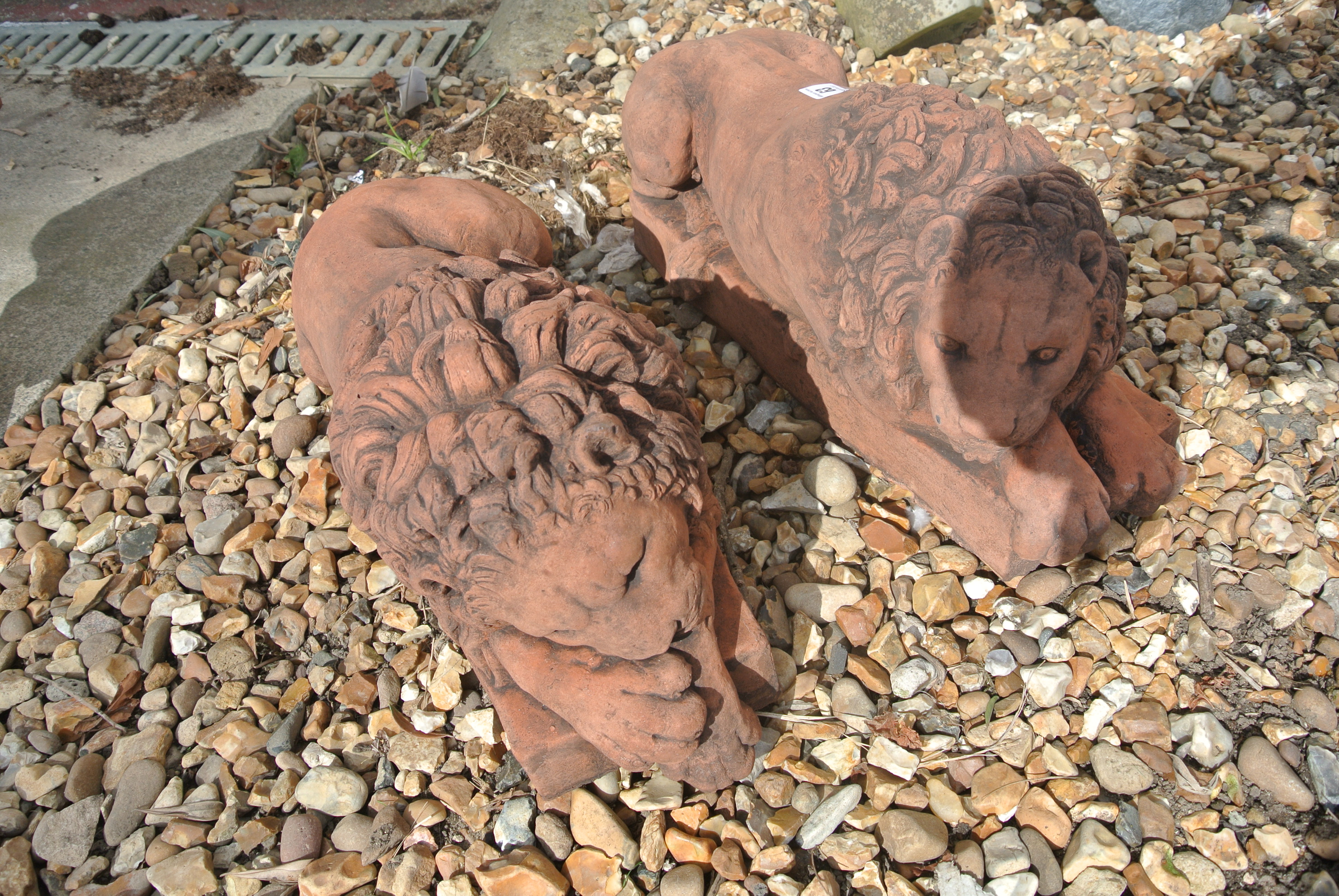 A pair of recumbent lions in cast stone after a 19th century pair by Canova - Length 48cm x Width