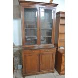 An Edwardian mahogany bookcase cabinet with two glazed doors above two drawers and two cupboard