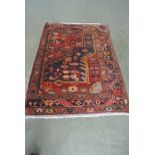 A hand knotted woolen Persian rug - 1.10m x 0.