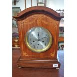 An 8 day striking mantle clock with a brass movement stamped Lenzkirch in a carved oak case with a
