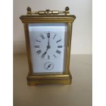 A French brass carriage clock with alarm striking on two gongs - Height 14cm - ticks but stops,