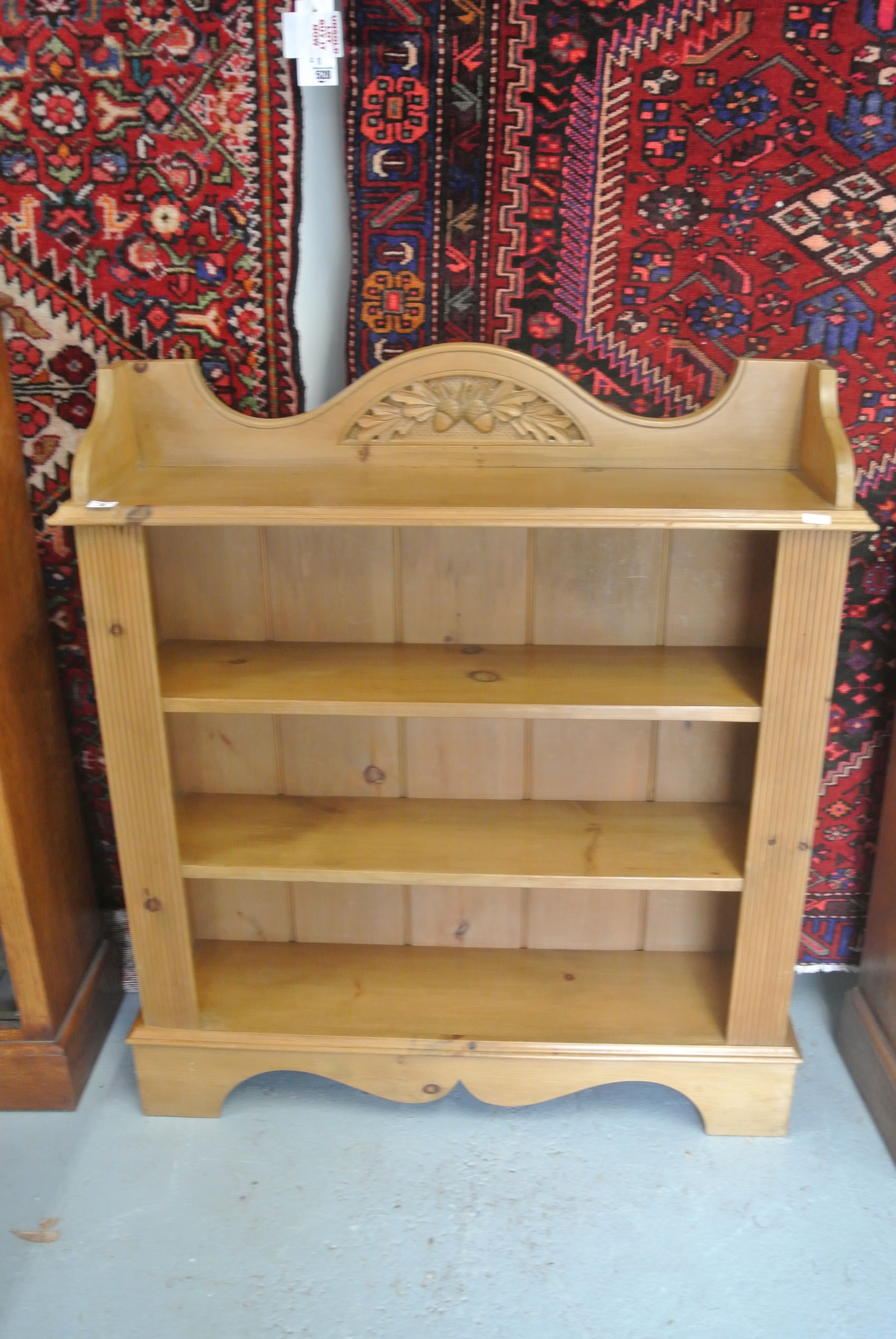 A pine bookcase with reeded panels to front and with upstand featuring carved acorns - Height 107cm