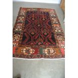 A hand knotted woolen Persian rug - 2.13m x 1.