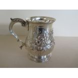 A silver hallmarked mug with single handle and foliate embossed decoration - London 1870/71 -