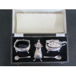 A hallmarked silver cruet set consisting salt and spoon, mustard and spoon,