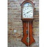 A 19th Century Continental mahogany wallclock with a painted arched dial and pillar movement