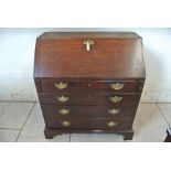 A Georgian oak bureau with a stepped interior over four graduating drawers - 105cm tall x 95cm x