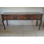 An 18th Century oak dresser base with three drawers on shaped front legs with pad feet - 87cm tall