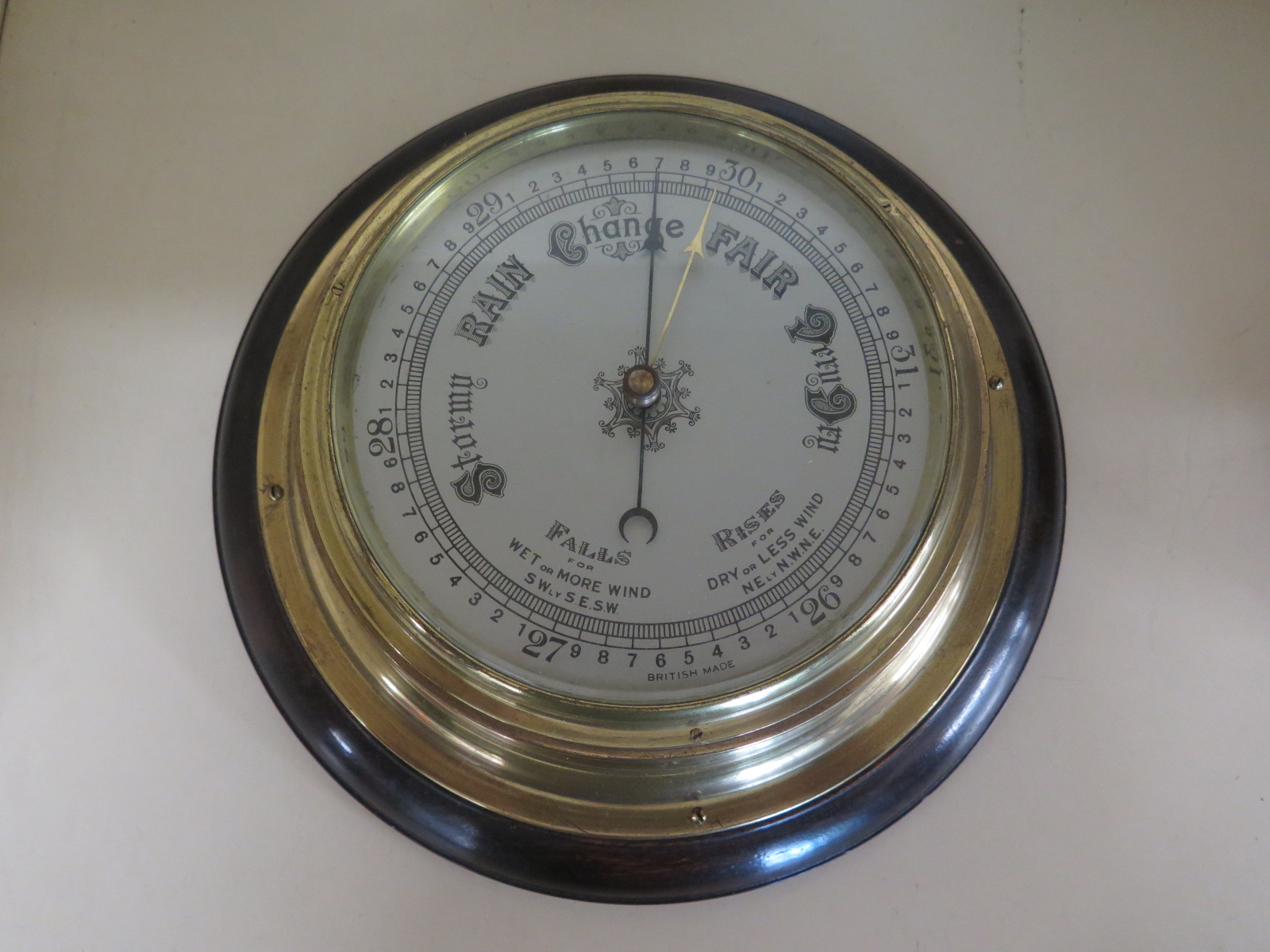 A mahogany and brass bulkhead aneroid barometer - 27cm diameter