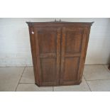 A 19th Century oak corner cupboard with shaped shelves enclosed by two panel doors - 103cm tall x