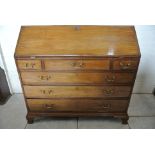 A Georgian mahogany bureau with a fitted interior above three small and three long drawers on ogee