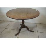 An 18th Century oak tilt top side table with old repairs to the top