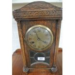 A striking mantle clock in an oak case - in working order - 38cm high