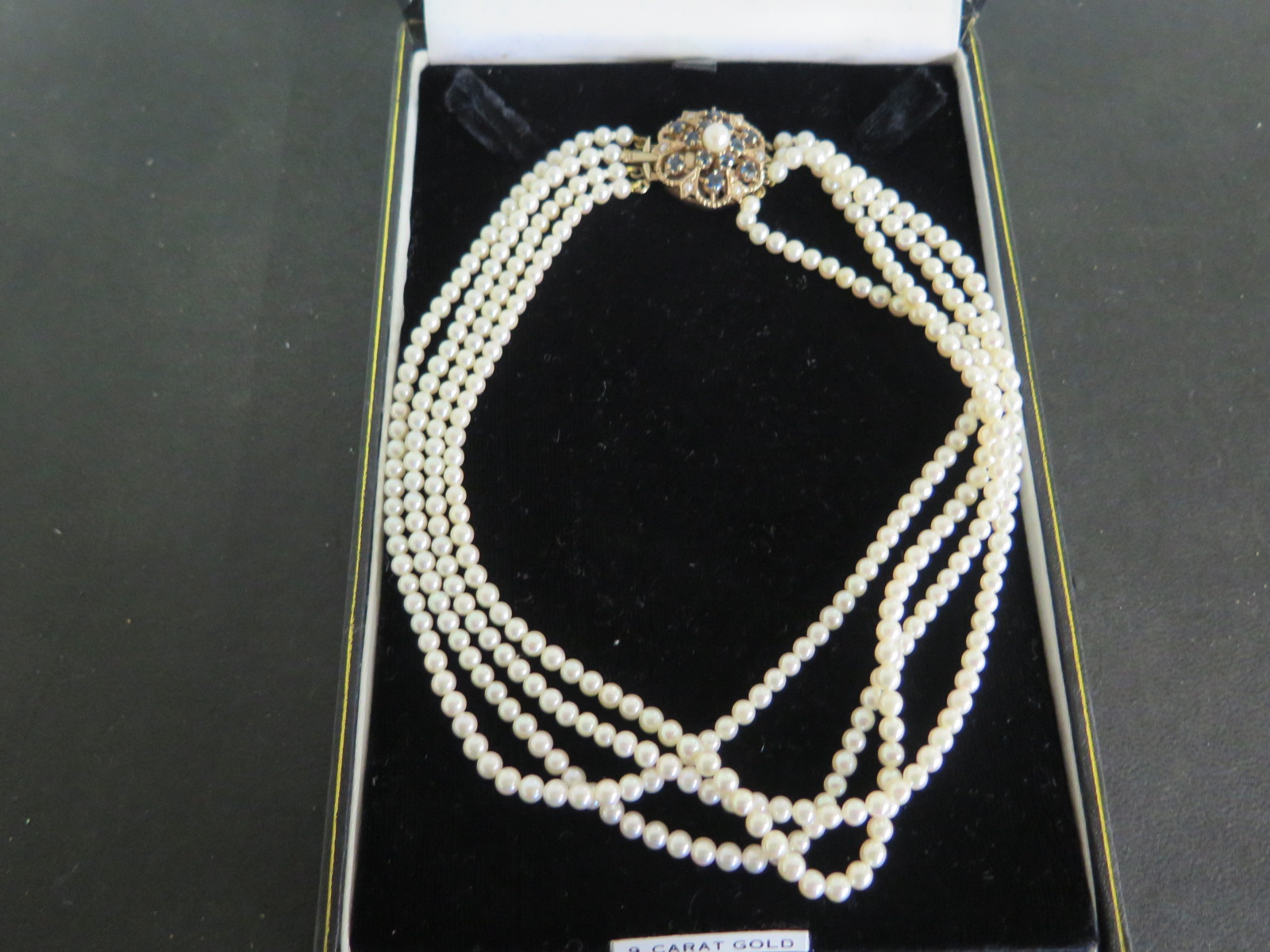 A four string pearl choker with 9ct gold clasp - 34cm long - in good condition - pearls