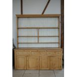 A 19th Century Pine Dresser with a plate rack with painted back-boards over three drawers and four