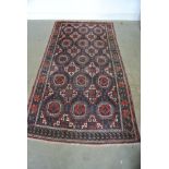 A hand knotted woollen rug with geometric centre and stylized border - 250cm x 124cm - some usage