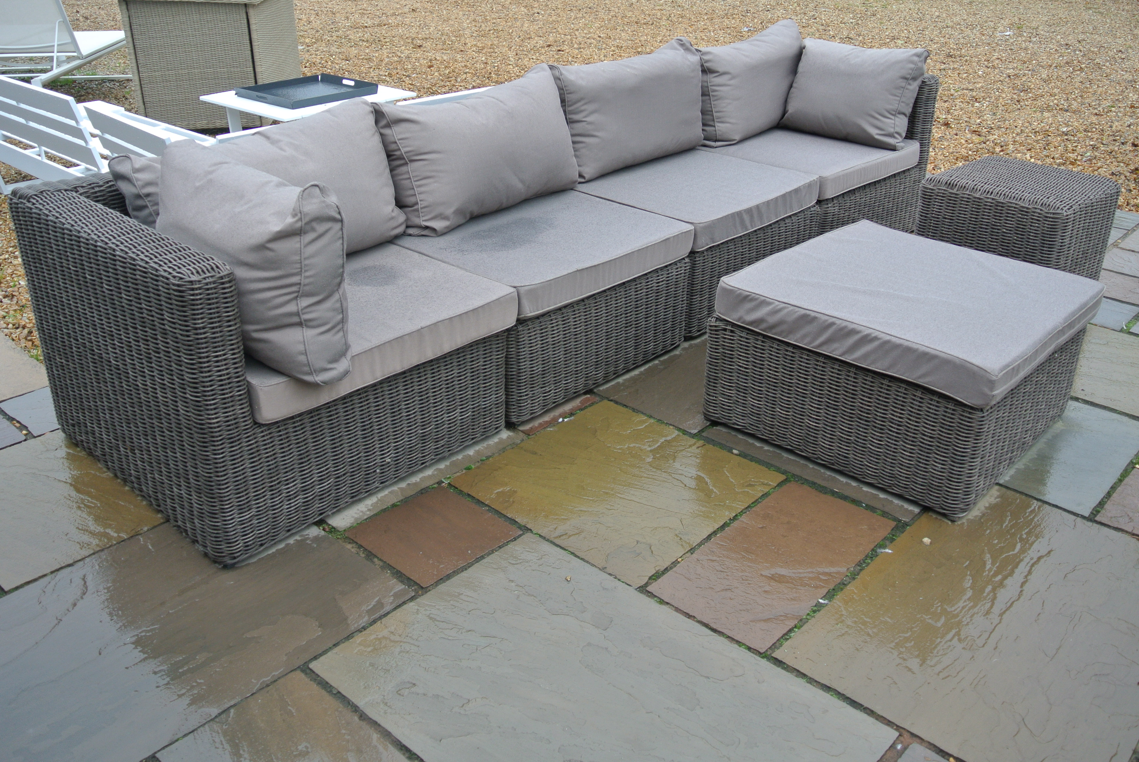 A secondhand Rattan Garden or Conservatory Sofa and two Stools with Cushions - in good condition -