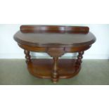 A mahogany washstand raised on three turned legs bearing a paper label for Howard and Sons - Width