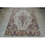 A Hand Knotted Woollen Rug with a cream field and central medallion and floral swag border - 221 cm