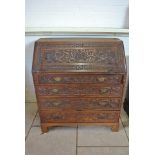 A 19th Century oak four drawer bureau with later Dragon and Medusa carving - 107 cm tall x 95 cm x