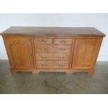 An 18th Century Style Oak Dresser with Five Drawers - flanked either side by arched panelled doors