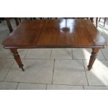 A 19th Century mahogany windout dining table with one leaf on turned reeded legs,